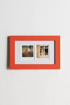 an orange and white photo frame with two pictures hanging on the wall next to each other