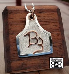 Made upon order - allow approx 4 week lead time. One sterling silver livestock ear tag pendant, features: - Your custom brand overlaid in brass, copper, or sterling silver (choose from drop-down box) - Nicely sized, measuring approx 1.25" width x 1.5" tall - Hangs from 18" chain - Handcrafted, hand engraved border and textured background - Please send us your brand image or drawing (clearly oriented) via an Etsy conversation Hand Engraved Jewelry, Livestock Branding, Cowgirl Bling Jewelry, Western Style Wedding, Cow Ears, Cattle Brands, Stock Show, Girl Western, Cowgirl Bling