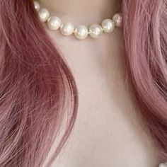 a woman with long pink hair wearing a pearl choker and pearls on her necklace