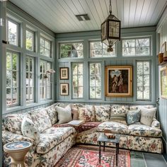 a living room filled with furniture and windows next to a painting on the wall above it