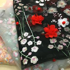 three different types of fabric with flowers and leaves on them, one is black and the other is red