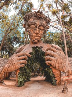 a large wooden statue in the middle of a forest