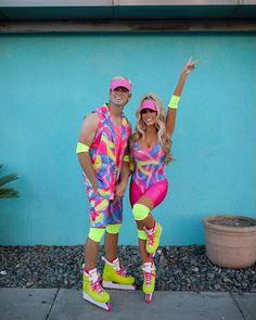 a man and woman dressed up in colorful outfits posing for a photo on the sidewalk