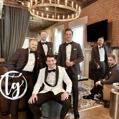 a group of men in tuxedos posing for a photo