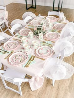 the table is set with pink and white plates