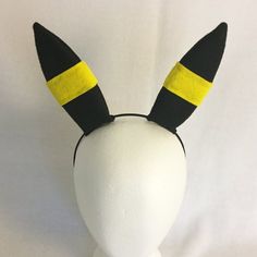 a white mannequin head with black and yellow ears