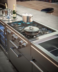 a stove top oven sitting next to a counter with pots and pans on it