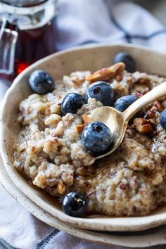 a bowl full of oatmeal with blueberries and walnuts on top