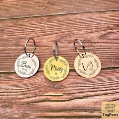 three personalized keychains are shown on a wooden surface with the name mary