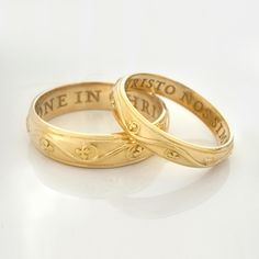 two gold wedding rings with the words we are in love written on each one side