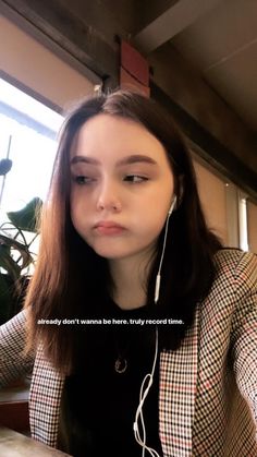 a woman with ear buds sitting at a table