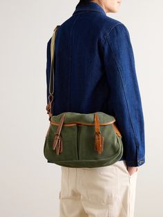 Bleu de Chauffe's messenger bag is modelled on a traditional fisherman's musette. Made at the brand's workshop in France, it's crafted from smooth green suede with brown leather buckle fastenings and a durable canvas strap. It opens up to a spacious compartment that's fitted with a zip pocket to keep your phone or cardholder secure. Porter Bag, Messenger Bag For Men, Canvas Weekender Bag, Suede Backpack, Tom Ford Bag, Leather Weekender Bag, Canvas Messenger Bag, Wardrobe Edit, Luxury Sneakers