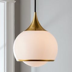 a white and gold colored light hanging from a ceiling fixture in a living room or bedroom