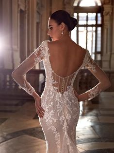 a woman in a white wedding dress with an open back