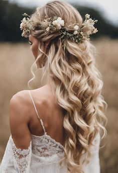 a woman with long blonde hair and flowers in her hair, wearing a white dress