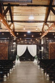 an indoor wedding venue with white drapes and lights