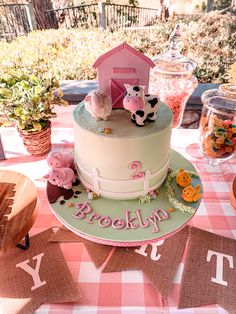 there is a cake on the table with farm animals and letters that spell it's 2