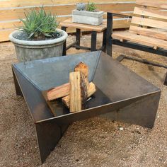 a table made out of metal and wood in the shape of a boat with logs sticking out of it