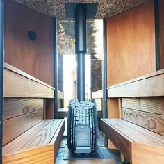 some wooden benches and a wood stove in a room