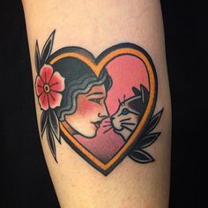 a heart shaped tattoo with a woman kissing a cat