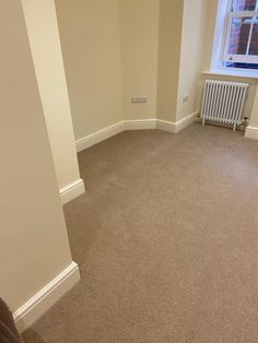 an empty room with a radiator and window