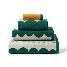 three towels stacked on top of each other in green and white waves with yellow accents