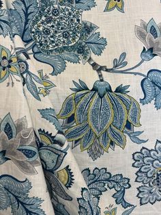 a blue and yellow floral print fabric with large flowers on the bottom half of it