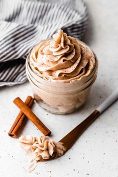 an image of a dessert in a jar with cinnamon sticks