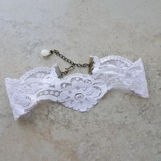 "This lovely white choker necklace is made up in a white floral patterned light weight vintage lace. The around neck measurement of the choker is 12\" on first jump ring attachment and there is an extension chain for adjustable sizing to 15\". The lace is a scallop design and at widest point is 2\". The over all length of the choker including the chain extension is 15\". The chain extension has a dangle white teardrop crystal bead accent. There is an antique brass hook closure for adjustable fit White Choker Necklace For Wedding, White Wedding Choker Necklace, Delicate White Choker For Wedding, Delicate White Wedding Choker, Delicate Adjustable Choker For Wedding, Adjustable White Necklace For Wedding, Elegant Adjustable Lace Choker, White Adjustable Vintage Necklace, Delicate White Choker Jewelry