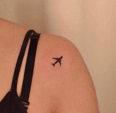 an airplane tattoo on the back of a woman's shoulder