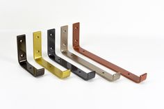 four different colored metal brackets on a white background