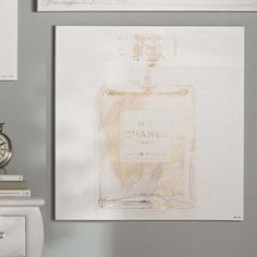 there are two pictures on the wall and one has a chanel bottle