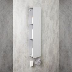 a white shelf mounted to the side of a wall next to a toilet paper dispenser