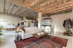 a living room filled with furniture and lots of lights hanging from the ceiling above it