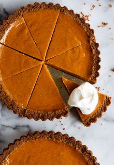 two pumpkin pies with one slice cut out