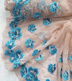 blue and white flowers are on the sheer fabric, which has been embroidered onto it