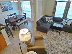 a living room filled with furniture next to a kitchen and dining room table in front of a window