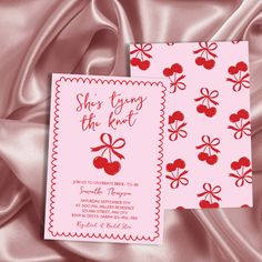 two cards with cherries and bows on them are laying on a pink satin surface