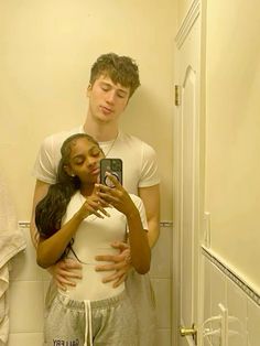 a man and woman taking a selfie in the bathroom