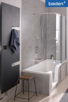 a bathroom with a bathtub, stool and towel rack on the wall next to it