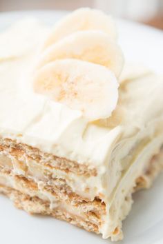 a piece of cake with white frosting and bananas on top