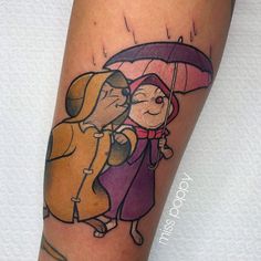 a couple kissing under an umbrella tattoo on the leg