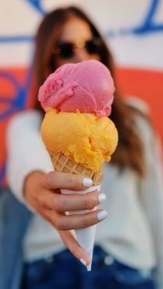 a woman holding an ice cream cone in her hand