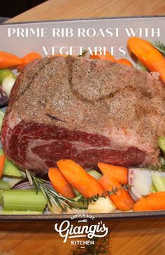 a large piece of meat with carrots, celery and other vegetables on a platter