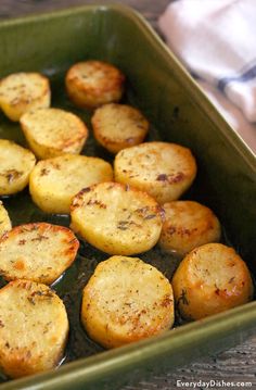 cooked potatoes in a green dish on a wooden table