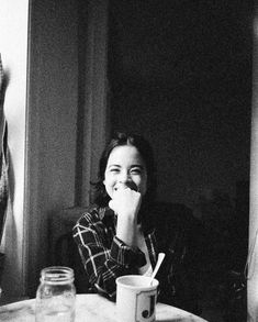 a black and white photo of a woman sitting at a table