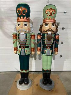 two wooden nutcrackers sitting on top of a cardboard box