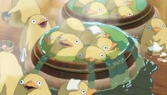 a bunch of birds that are standing in the water near some buckets filled with food