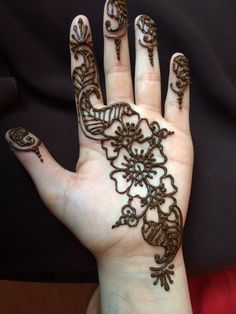 a woman's hand with henna tattoos on it