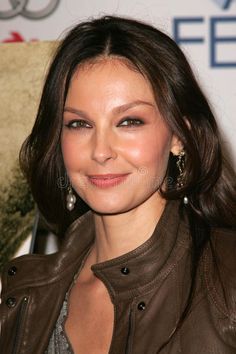 a close up of a person wearing a leather jacket and smiling at the camera,